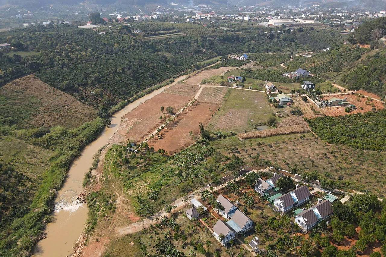 Ảnh flycam cụm phân lô Suối Thông Retreat, Mê Linh, Nam Ban: các dải đất vừa san dọc con đường trồng thông, bên cạnh dòng suối
