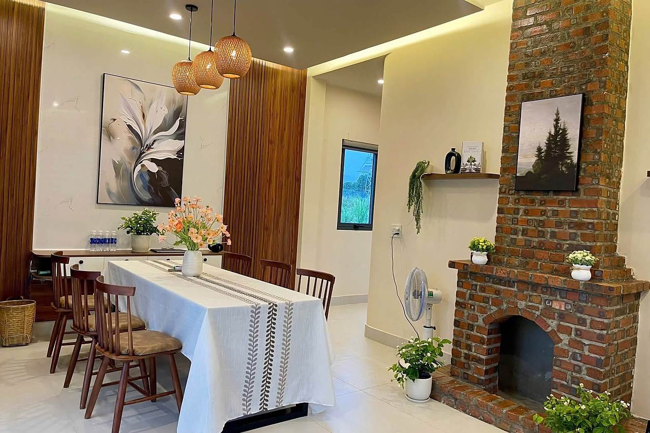 Hill House Village Nam Ban – bàn ăn, lò sưởi gạch mộc và tường lam gỗ