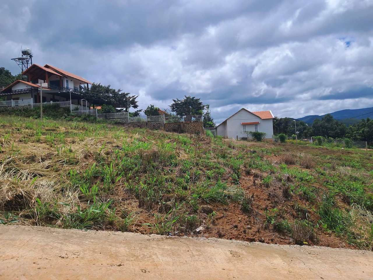 Lô đất 500m² Thành Công gần hồ Bãi Công Nam Ban nhìn từ đường bê tông, biệt thự & nhà xây phía sau