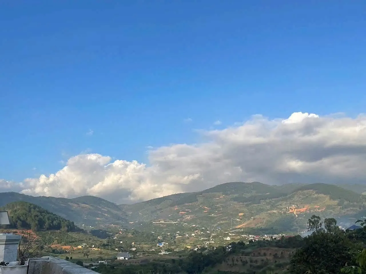 Toàn cảnh thung lũng Nam Ban nhìn từ nhà – núi đồi, khu dân cư và vườn cây, trời cao nguyên trong xanh