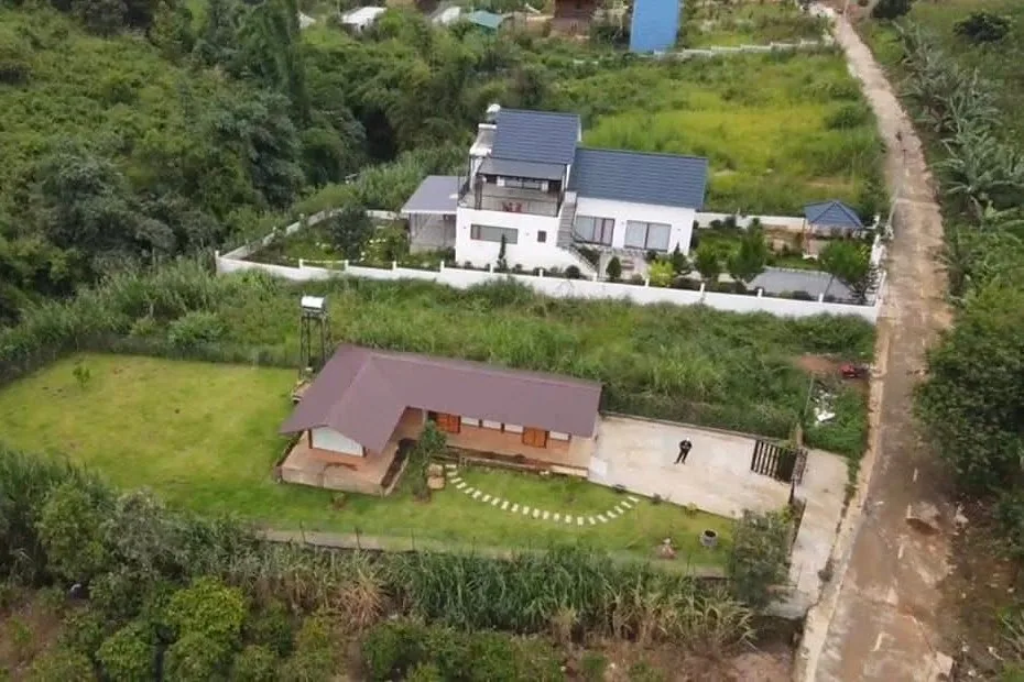 Flycam từ trên cao nhà gỗ giáp suối Nam Ban – sân cỏ, lối đá dạo, khu vila nghỉ dưỡng bên đường bê tông