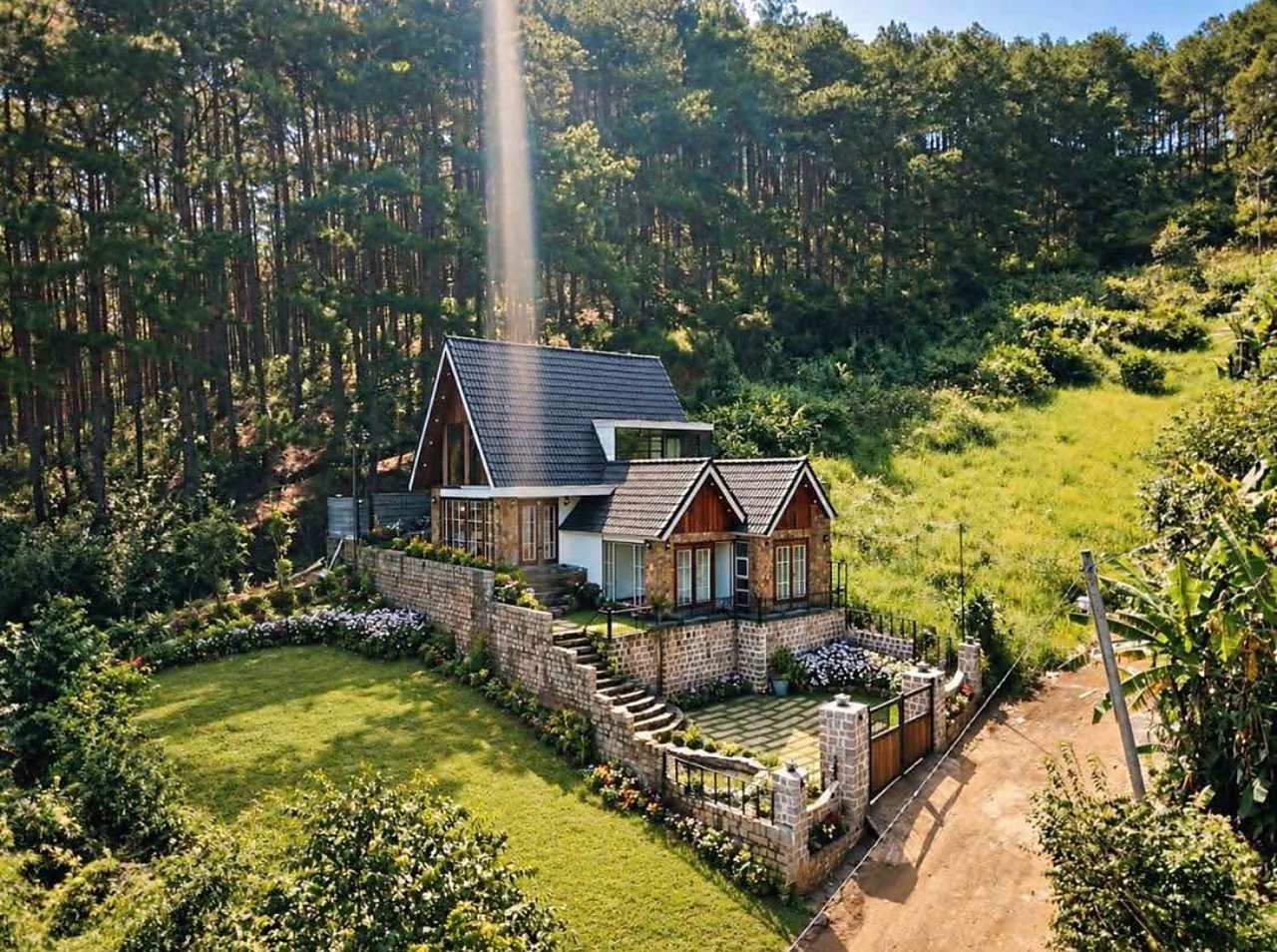 Nhà gỗ lim phong cách Đông Âu ở Mê Linh, Nam Ban nhìn từ trên cao: mái ngói xám, tường kè đá, sân cỏ, đồi thông ngay phía sau