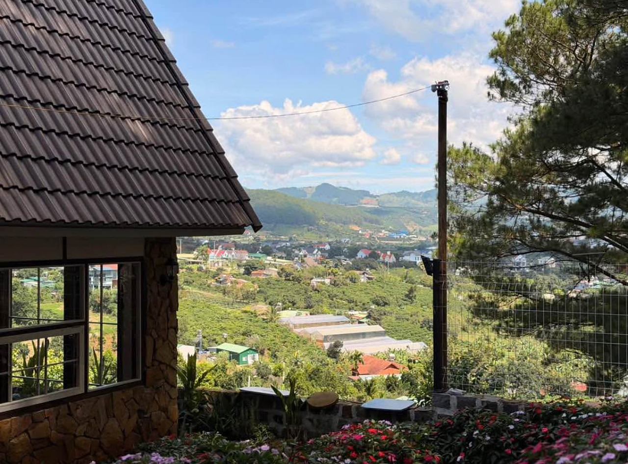 View từ hiên nhà gỗ lim Mê Linh, Nam Ban nhìn xuống thung lũng, vườn hoa trước nhà, núi phía xa