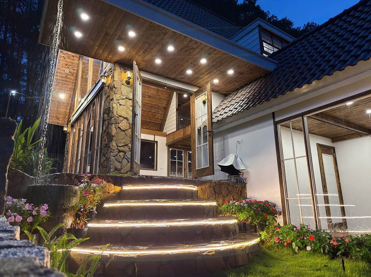 Bậc thềm đá có đèn lối vào nhà gỗ lim Mê Linh, Nam Ban buổi tối, trần gỗ, cửa kính lớn