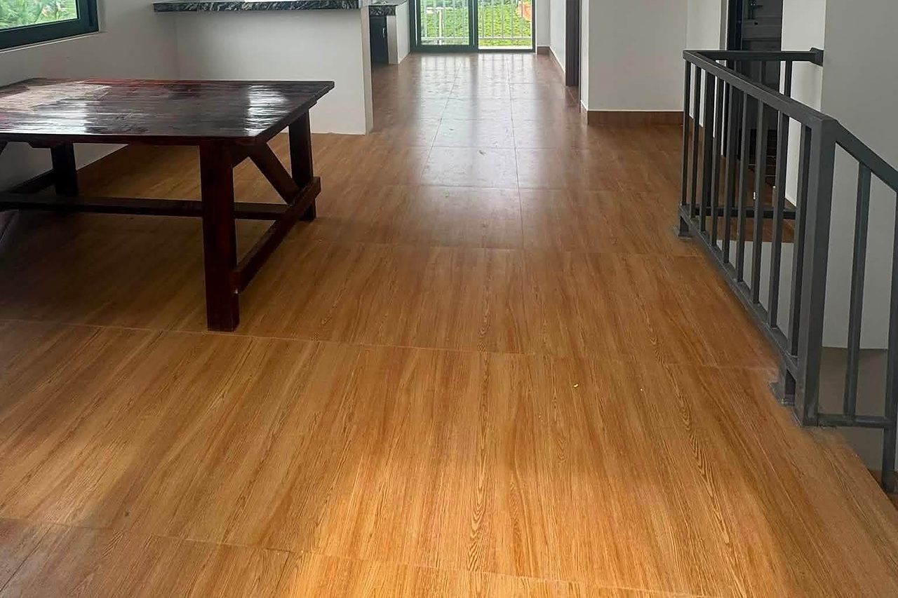 Phòng khách & bếp thoáng, sàn gỗ, cửa kính ra ban công nhìn ra thung lũng