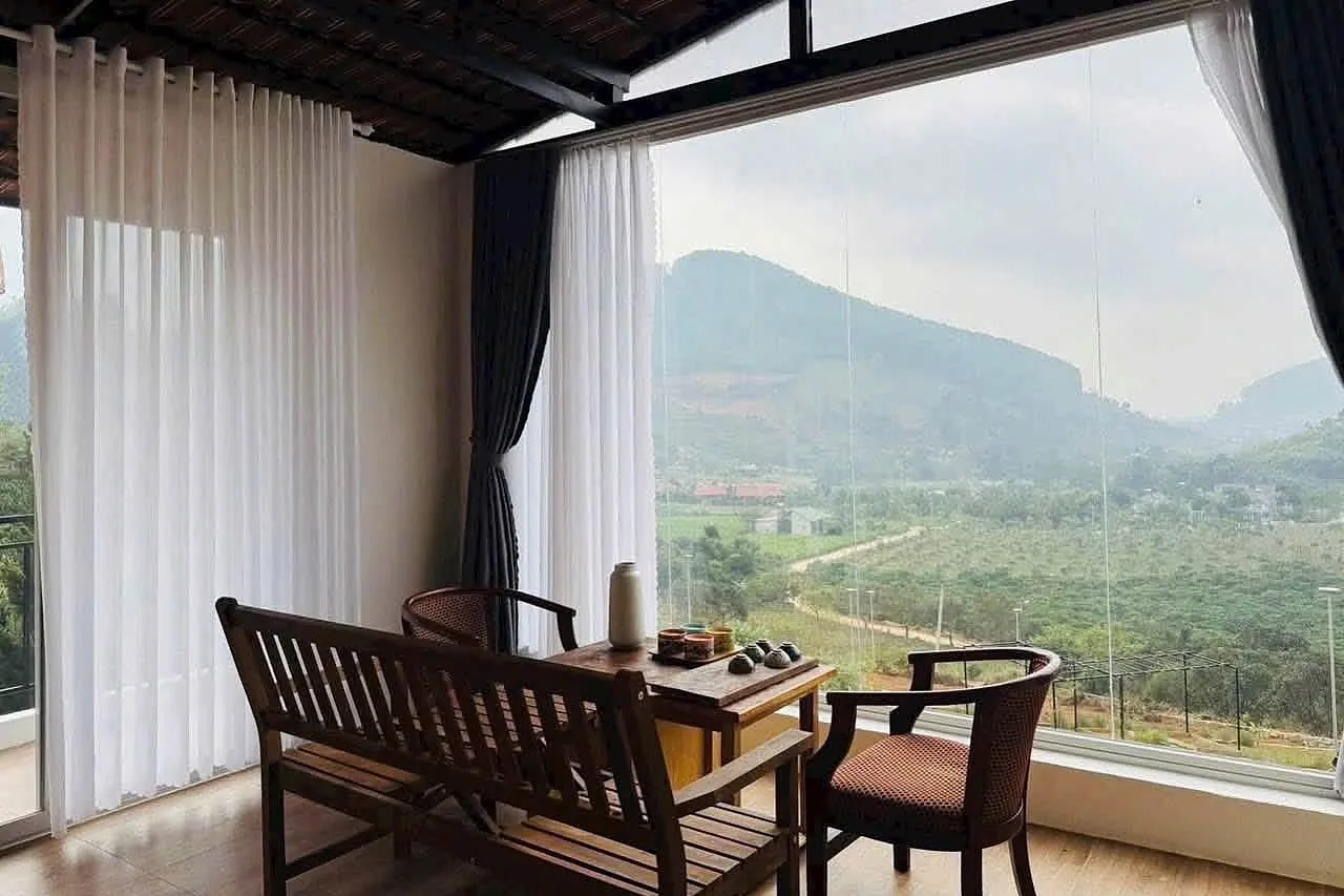 Góc trà bên cửa kính lớn nhìn ra núi và vườn ven Đà Lạt