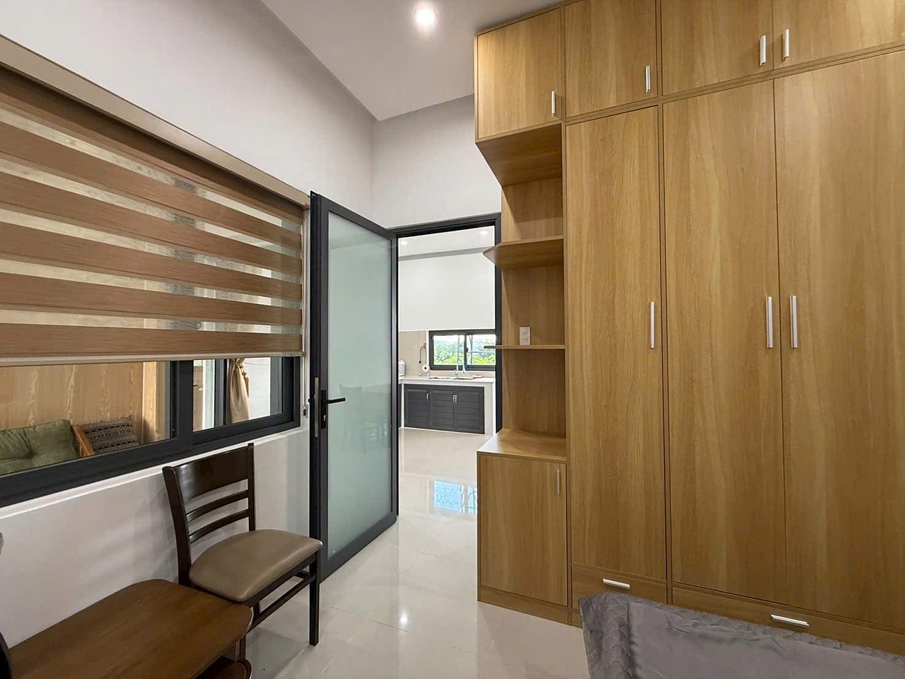 Phòng ngủ tủ áo gỗ, giường, cửa kính ra hành lang