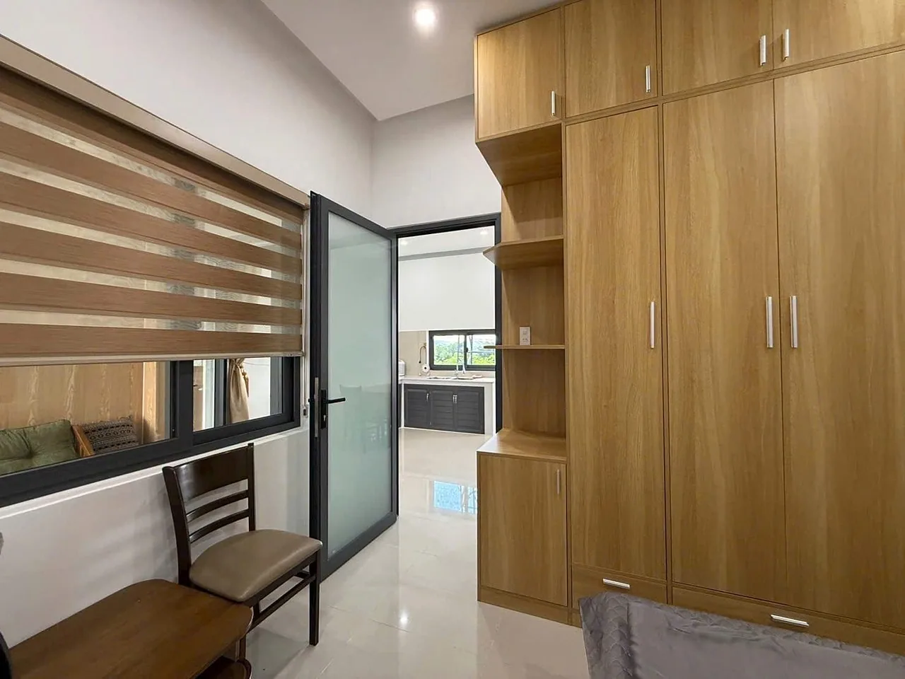 Phòng ngủ tủ áo gỗ, giường, cửa kính ra hành lang
