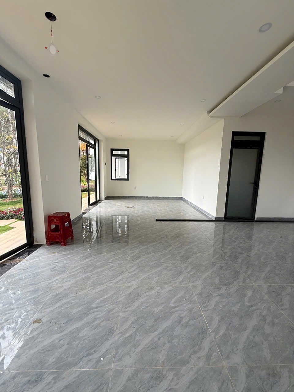 Không gian phòng khách villa HT86 Nam Ban – sàn đá marble, trần thạch cao, cửa kính ra vườn