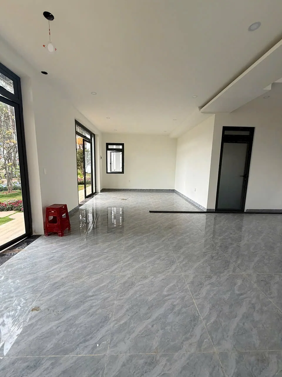 Không gian phòng khách villa HT86 Nam Ban – sàn đá marble, cửa kính ra vườn
