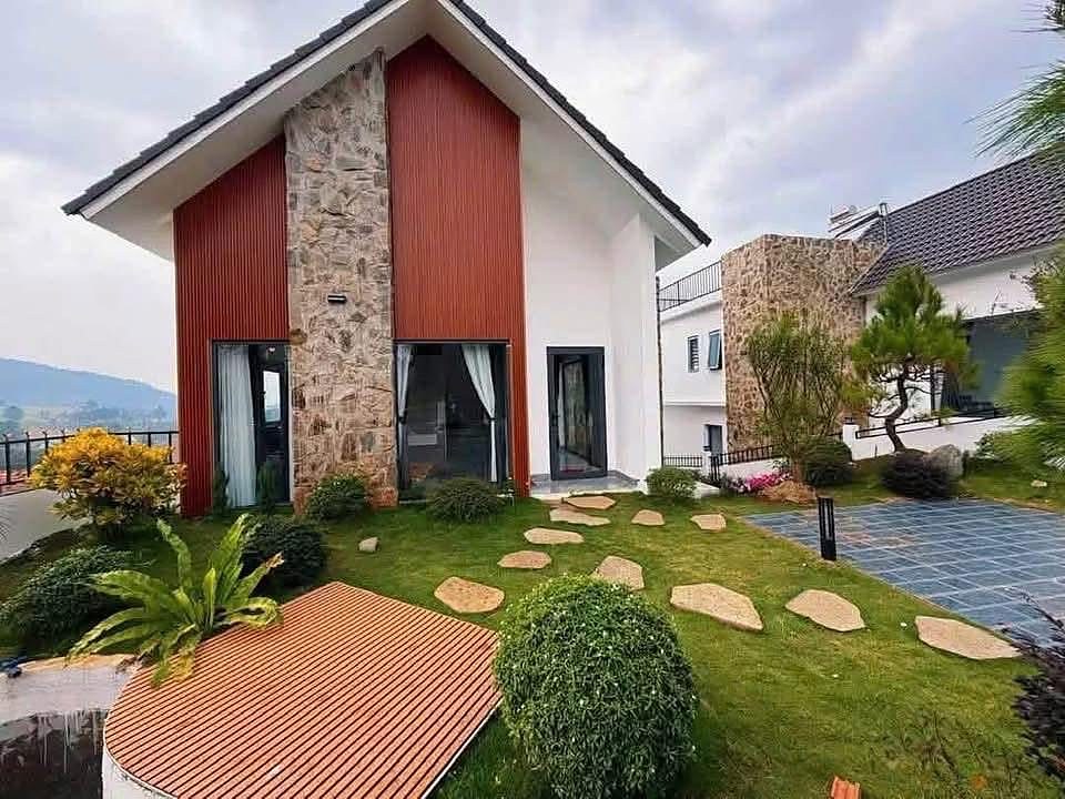Villa Nam Ban ban ngày – mặt đá tự nhiên, gỗ đỏ, sân cỏ và lối đá bước, view đồi