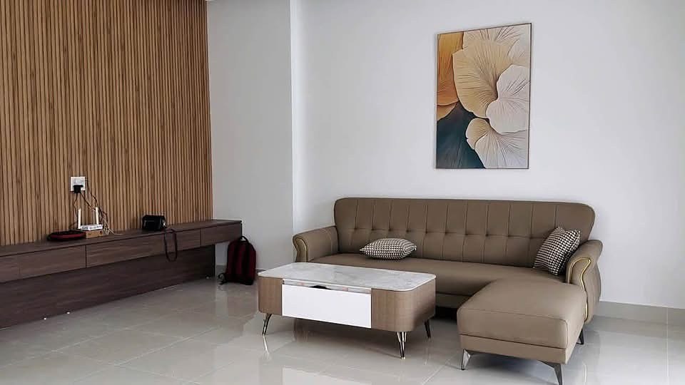Phòng khách villa Nam Ban với sofa, vách gỗ lam, sàn gạch bóng