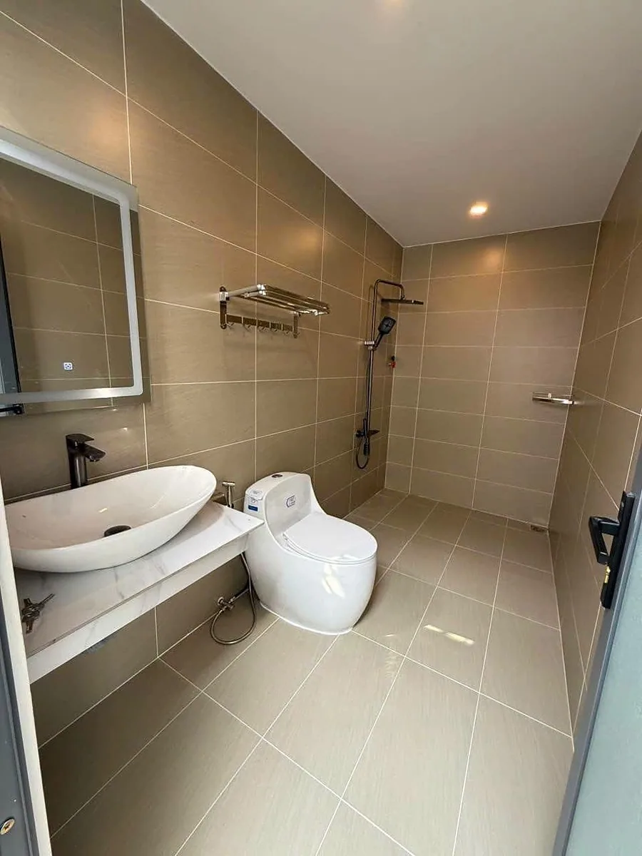 Nhà vệ sinh villa Nam Ban ốp gạch be, bồn rửa đá, vòi sen, gương đèn LED